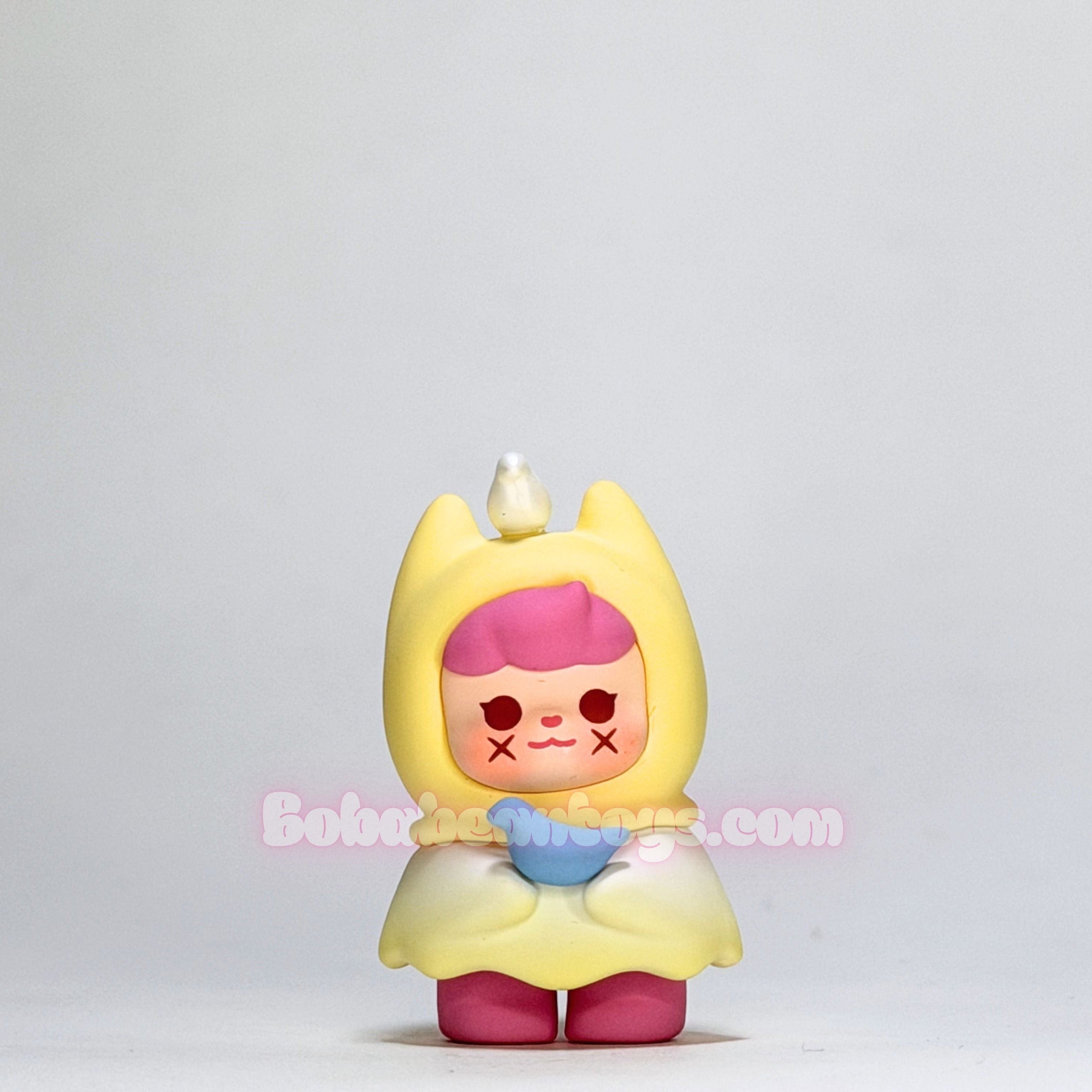 Toy figure with yellow hood and pink hair on a light gray background