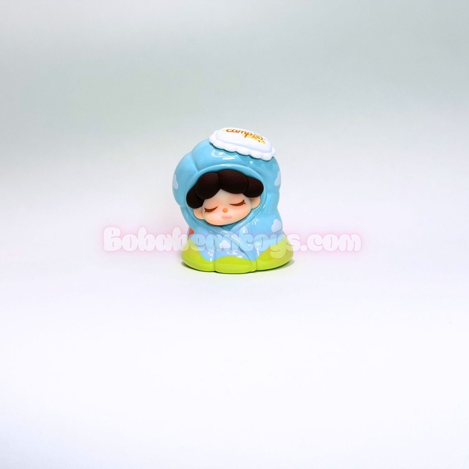 Small figurine of a character wearing a blanket on a white background
